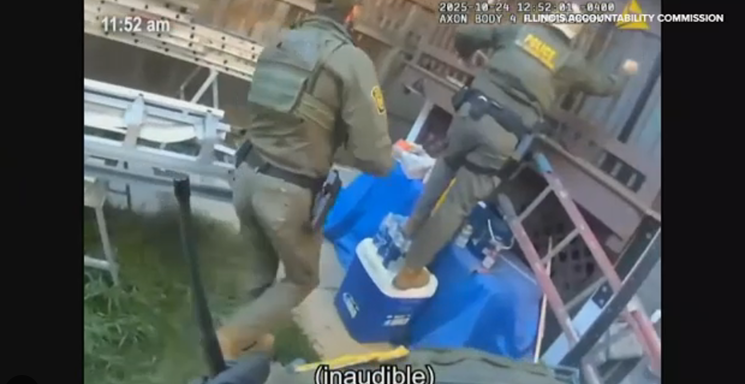 Body-worn camera frame showing two federal agents in tactical uniforms standing over a cooler and construction materials inside a fenced yard.
